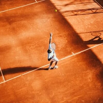 Man playing tennis on clay court