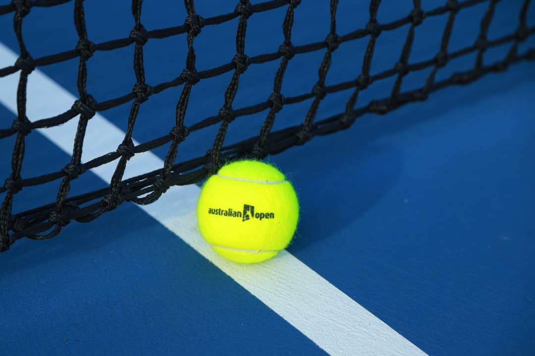 tennis ball on blue court